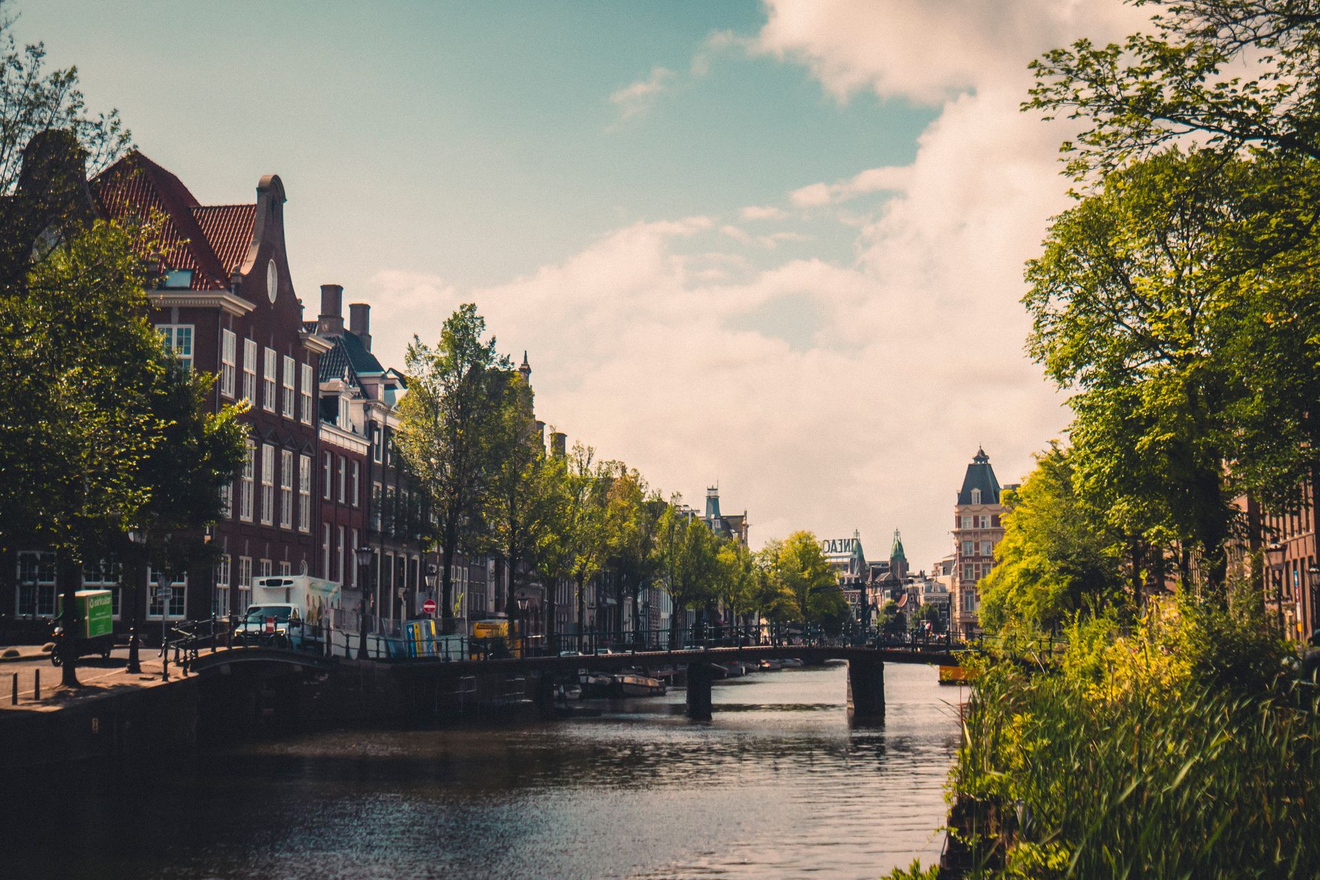 Amsterdam canal with bridge and historic Dutch houses on a sunny day