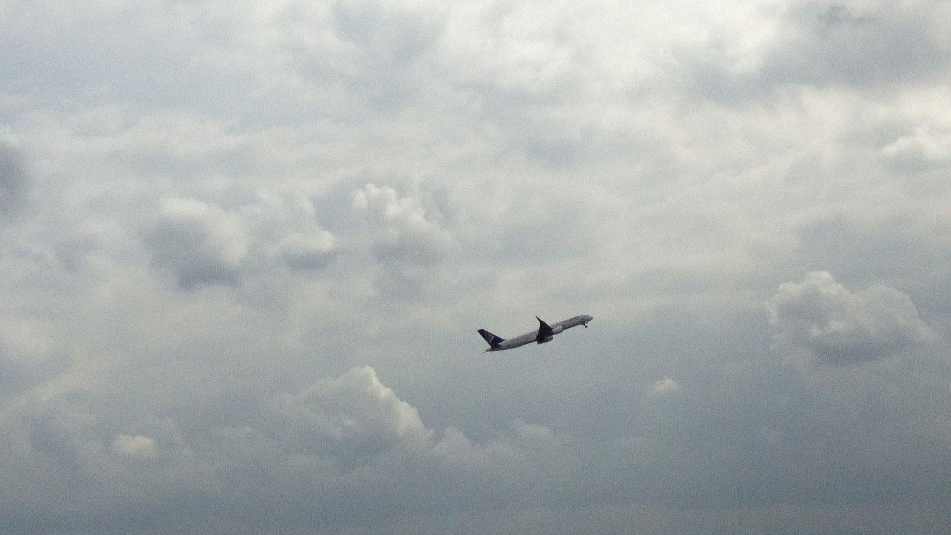 An airliner taking off into a hazy sky, with fuel costs pushing fares higher