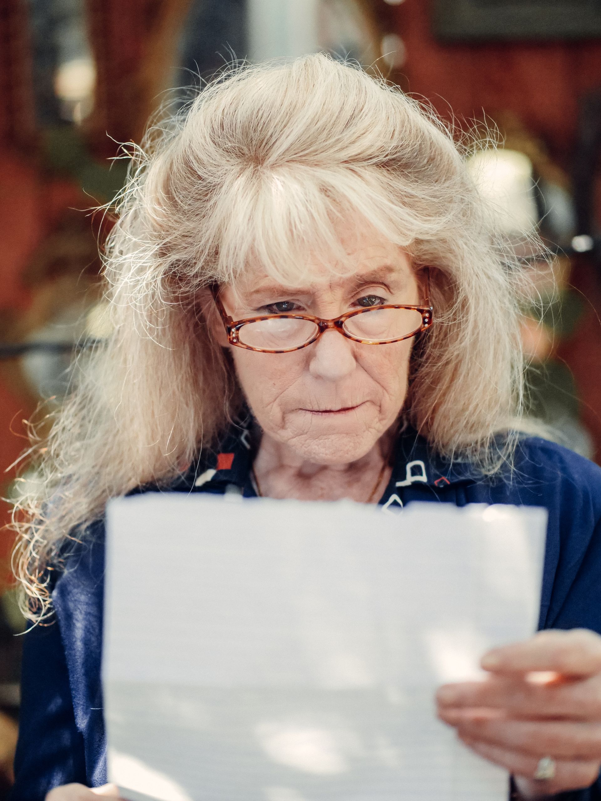 Senior woman reading an official letter about her Medicare health plan