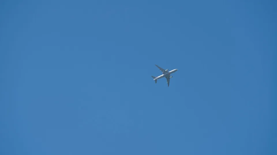 Commercial airplane flying high in a clear blue sky