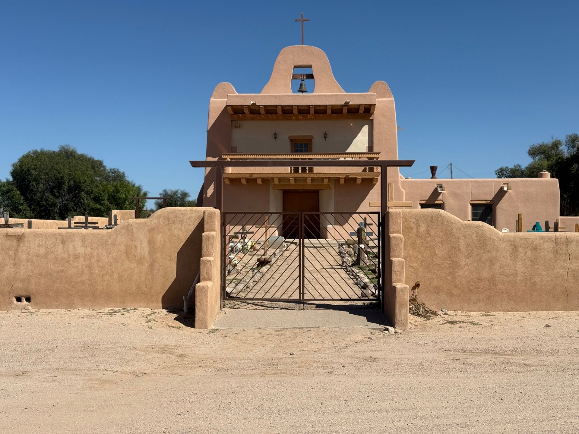 Historic adobe church with bell tower under clear blue sky in Santa Fe, New Mexico