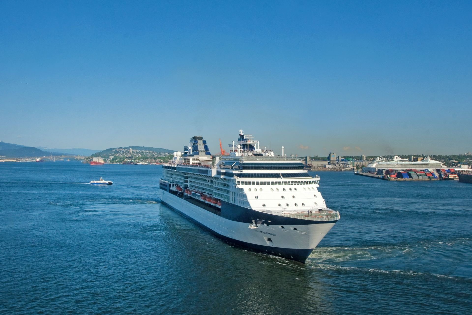 Large cruise ship sailing through calm waters under a clear blue sky