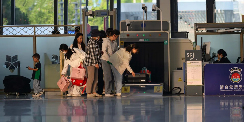 Travelers undergoing security screening at an airport terminal checkpoint